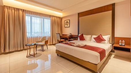An image of a room with a bed, a chair, and a table at M Pro Palace.