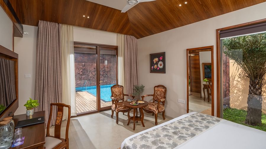 Pool Villa at Uday Backwater Resort featuring a sitting space next to the door to the crystal blue swimming pool 