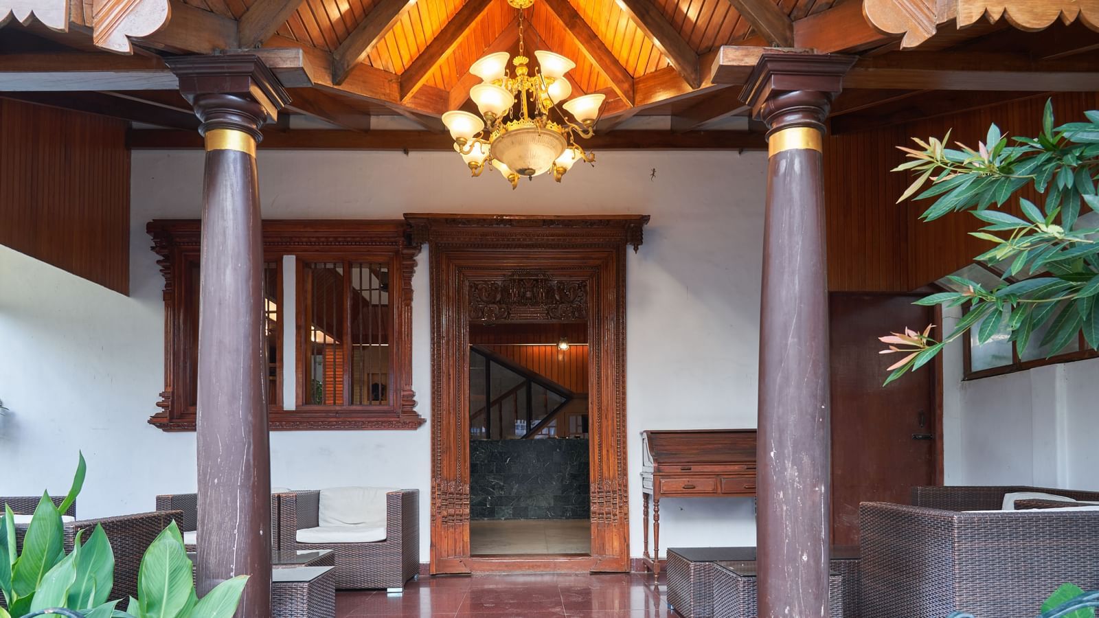 The welcoming lobby or entrance area of Hotel Mamallaa Heritage, featuring traditional wooden architecture, decorative elements, and warm lighting.