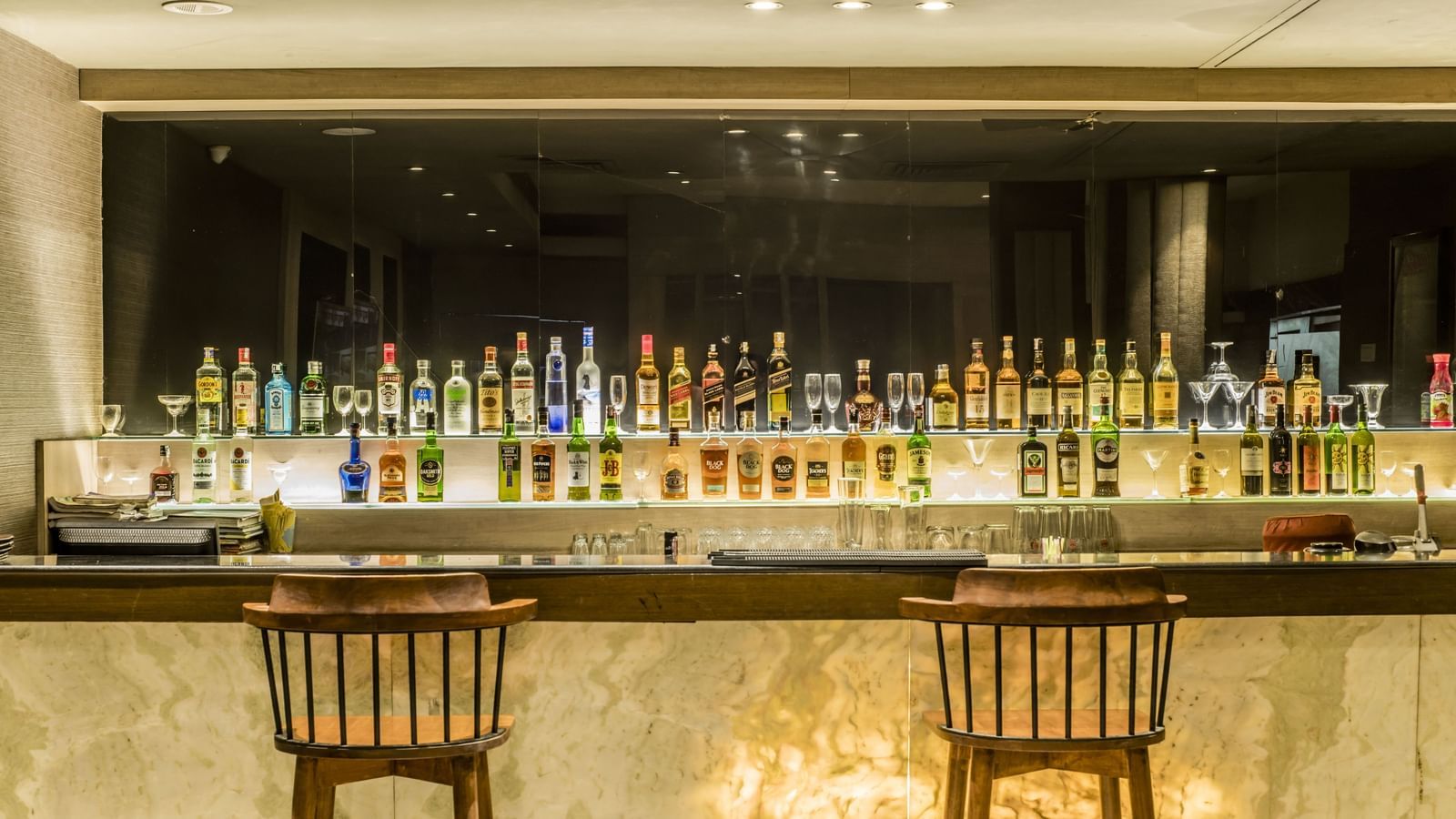 A view of the bar counter with bottles and seating at The Citi Residenci Hotel, Asansol. 