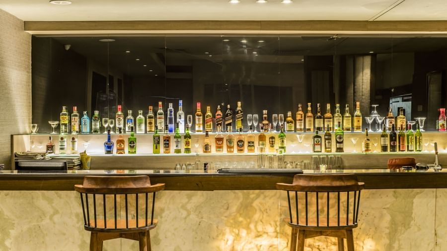 A view of the bar counter with bottles and seating at The Citi Residenci Hotel, Asansol. 