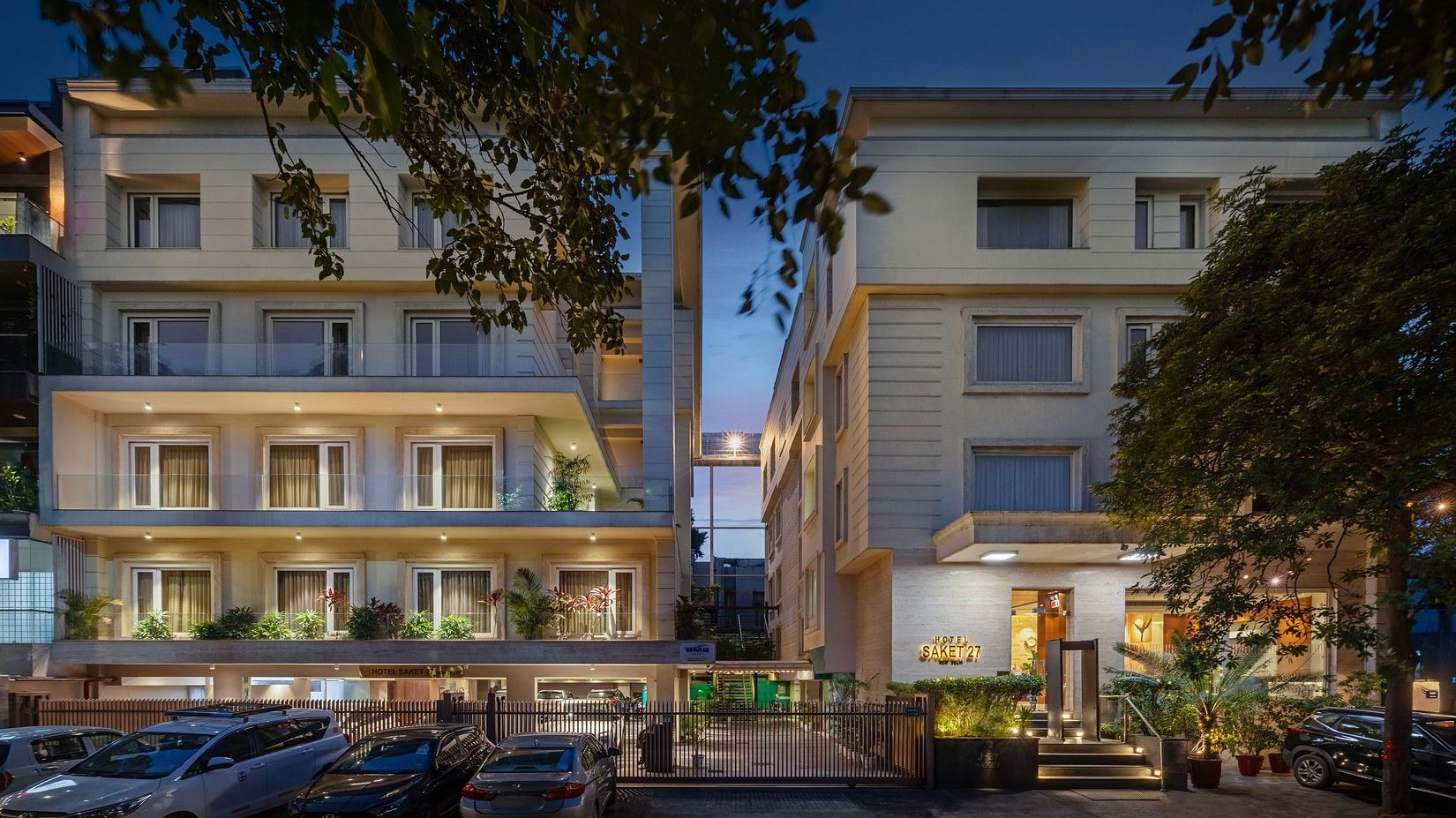 Exterior view of the beautifully lit Hotel Saket 27 at night