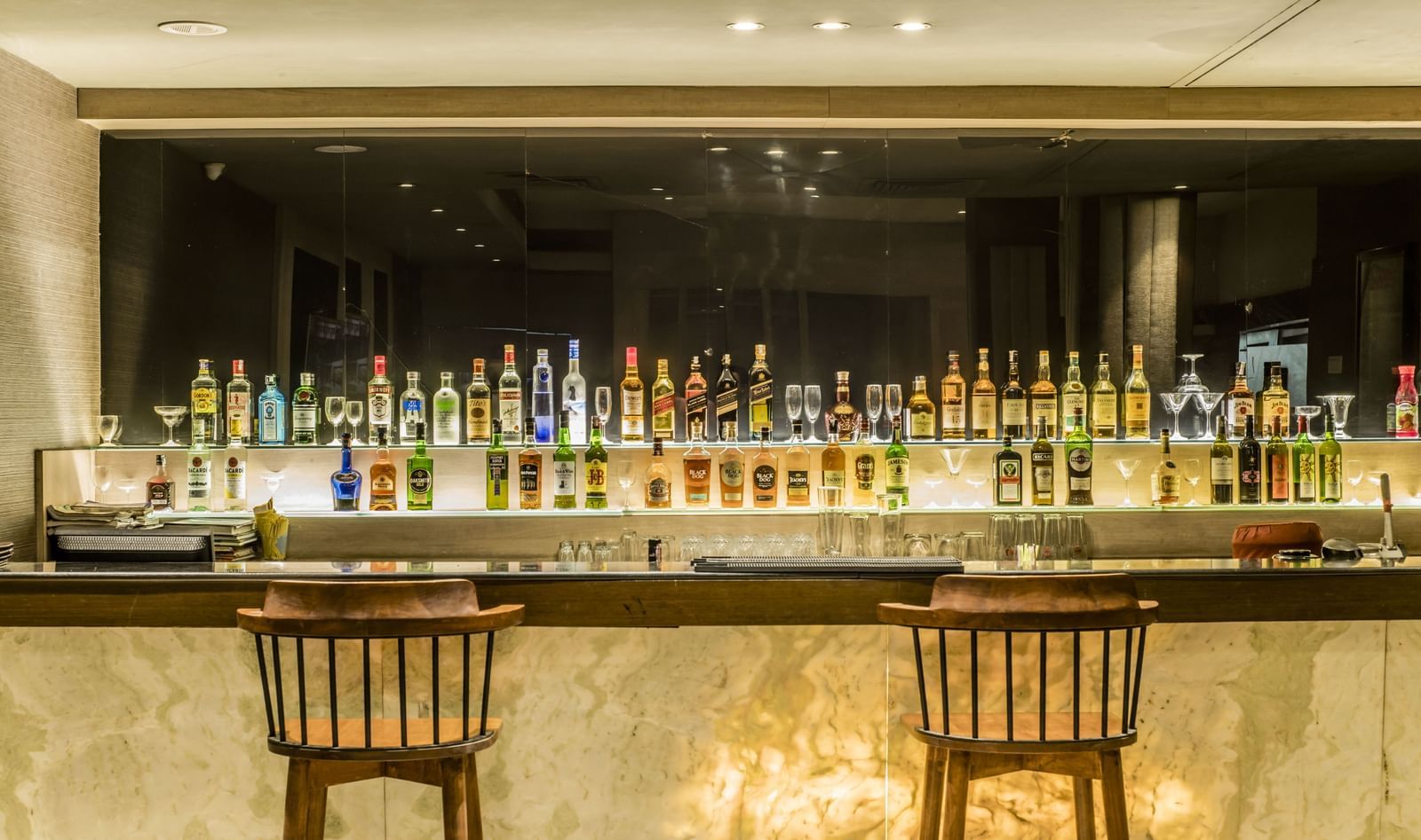 A view of the bar counter with bottles and seating at The Citi Residenci Hotel, Asansol. 