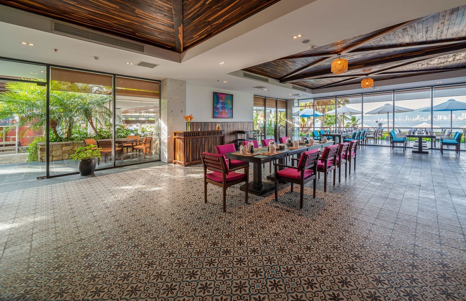 A view of the Sea Restaurant with maroon coloured chairs and lamps hanging from the ceiling - Alibu Resort Nha Trang