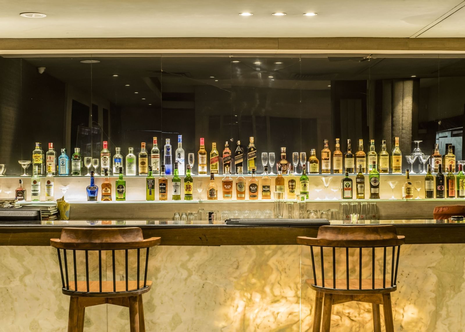 A view of the bar counter with bottles and seating at The Citi Residenci Hotel, Asansol. 