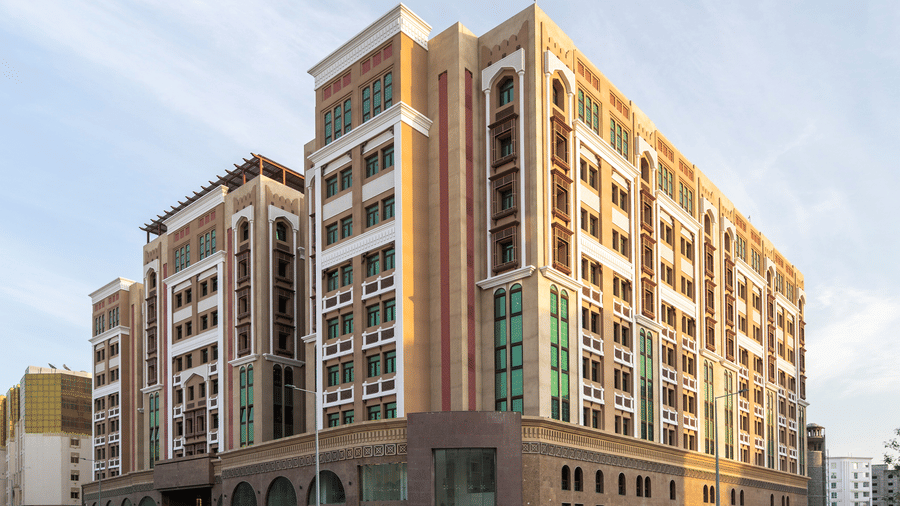 Facade image of La Maison Hotel, Doha with blue sky in the background