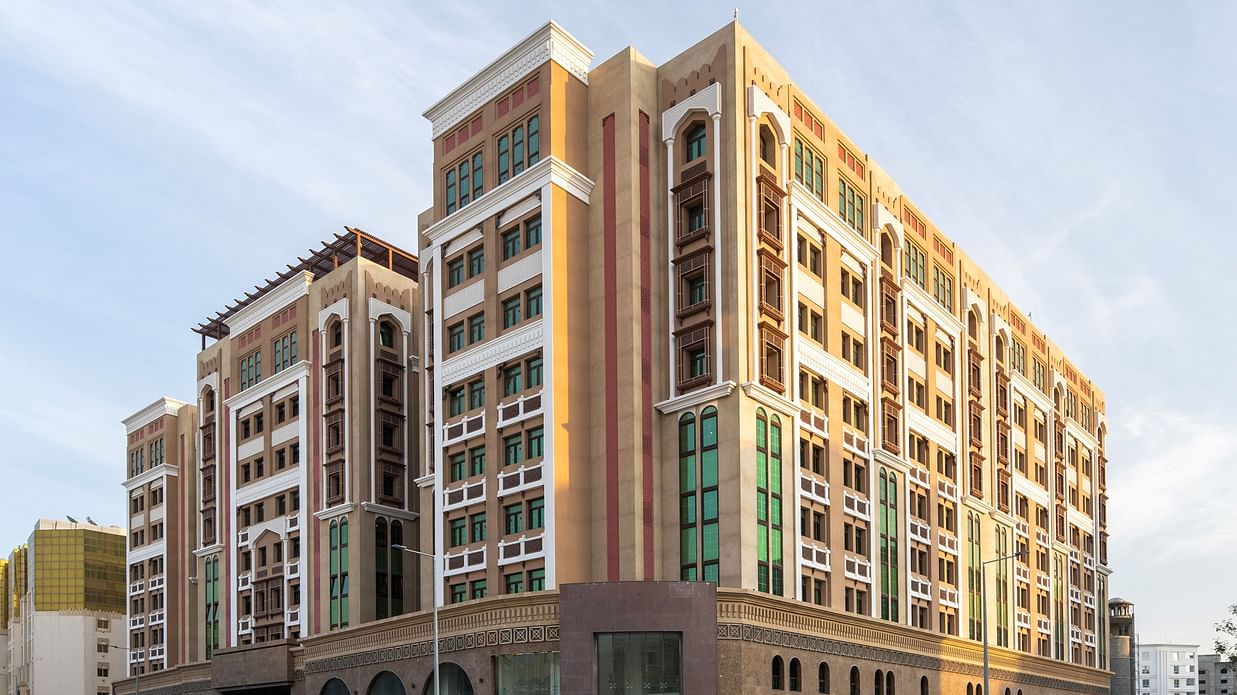 Facade image of La Maison Hotel, Doha with blue sky in the background