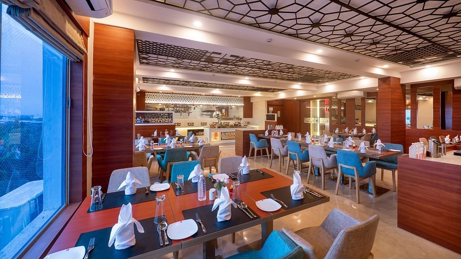 Dining area offering a variety of seating options and ambient lighting - Lords Eco Inn Shapar Rajkot