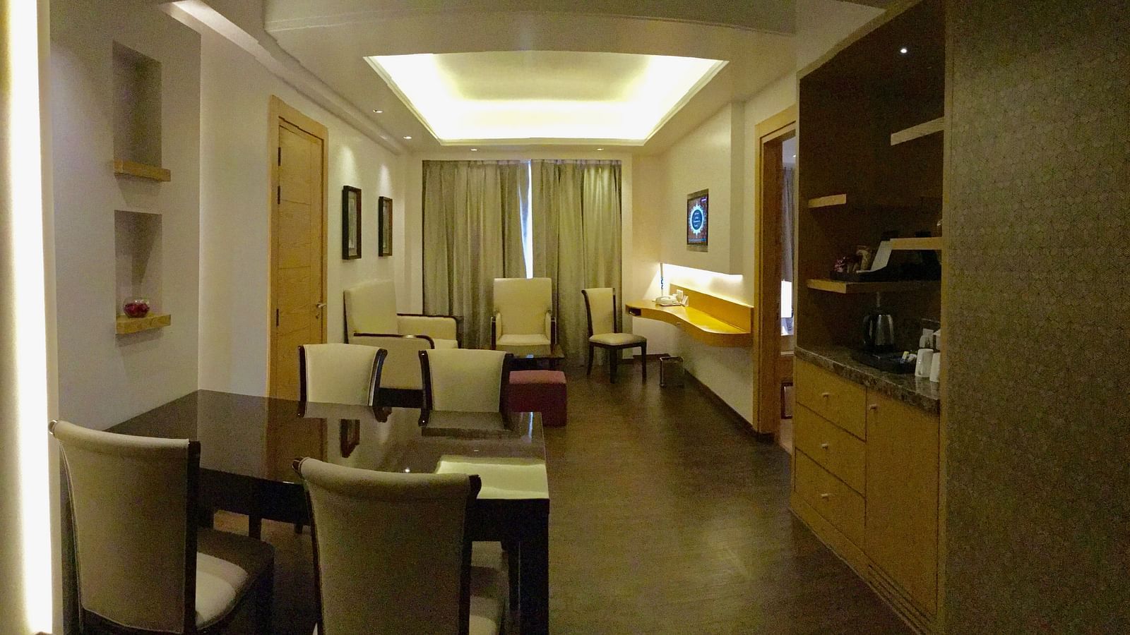 The living room in the Suite along with a dining table - Ramada by Wyndham, Ghaziabad, Vasundhara