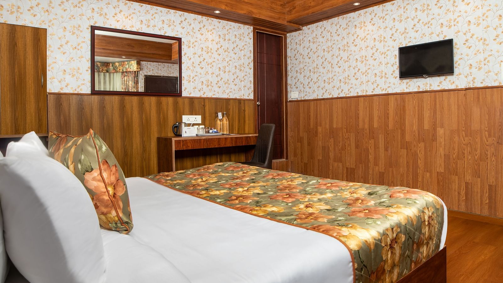 A side view of a bed in a room that has a TV on the wall | Summit Oakden Resort & Spa, Mall Road
