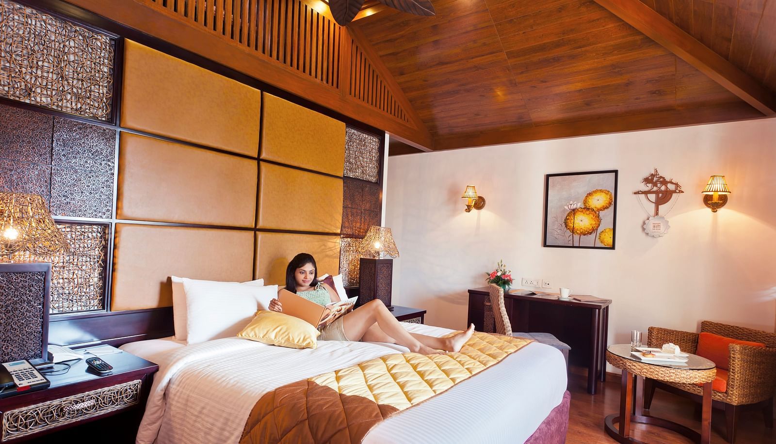 a woman sitting on a double bed inside BERMUDA Villa at Ocean Spray Puducherry