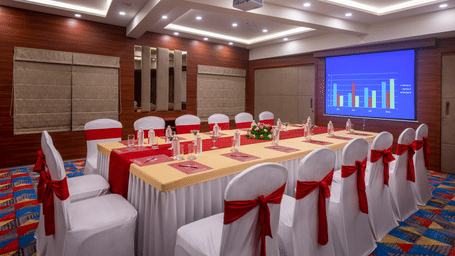 A neatly set up conference room in Lords Eco Inn Shapar Rajkot, featuring its audio visual system and modern interiors.