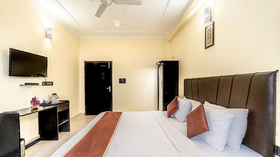 a bedroom at Flutter Hotels & Resorts featuring a bed, a television and a wardrobe