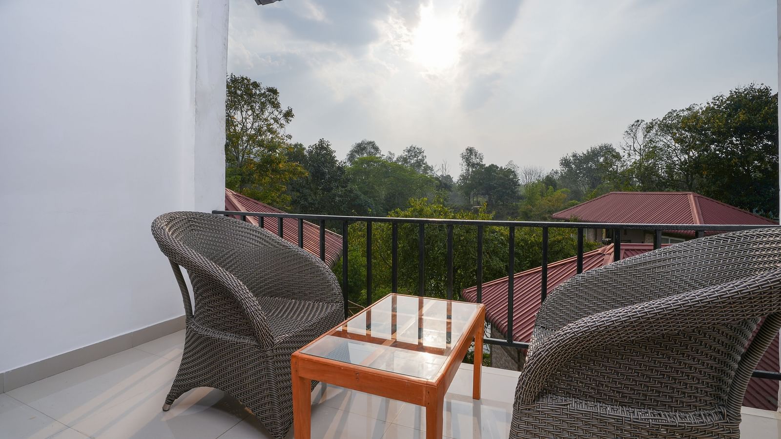 The suite with balcony offers a stunning nature view with furniture and a glass table at Summit Green Lake Tea Resort & Spa, Kaziranga