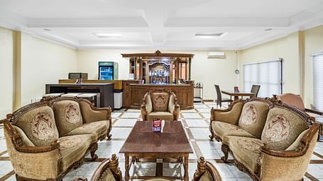 An image of the Amrutham Bar with seating arrangement with royal decoration and bright lit room - GReaT Trails River View Resort Thanjavur By GRT Hotels