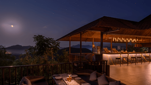 A rooftop bar at The Ananta Udaipur, with a stunning view of the city lights and hills under a starry night sky at  The Ananta Udaipur.