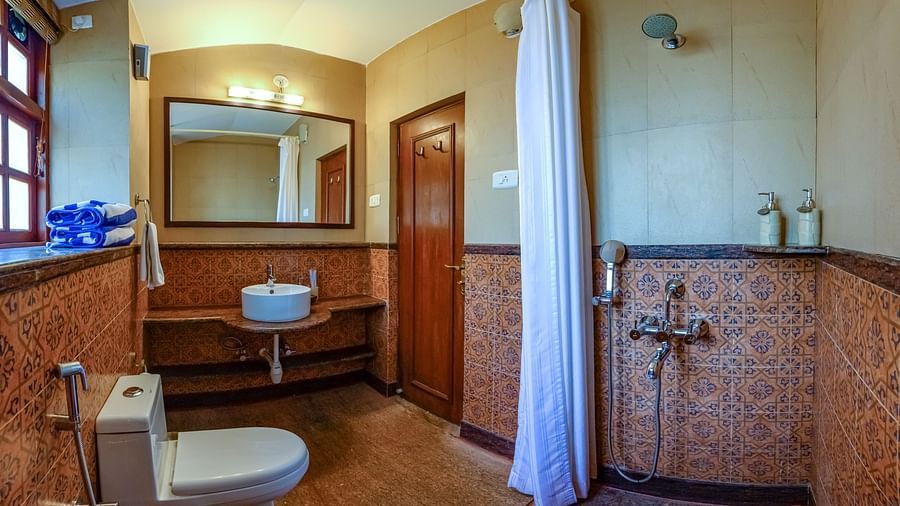 shower area commode and mirror at Babylonia - Cassis - River / Pool View room in Neemrana s Three Waters