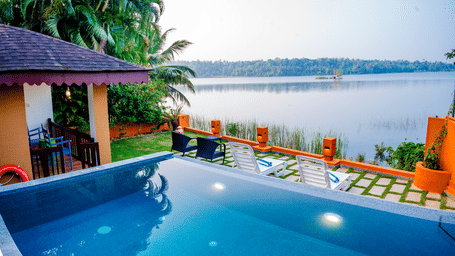 Swimming pool with a view of a lake at a tropical resort.