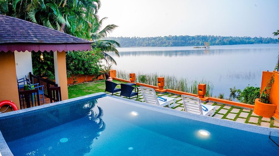 Swimming pool with a view of a lake at a tropical resort.