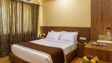 Standard room with bed and side table at Wyt Hotels, Rameswaram