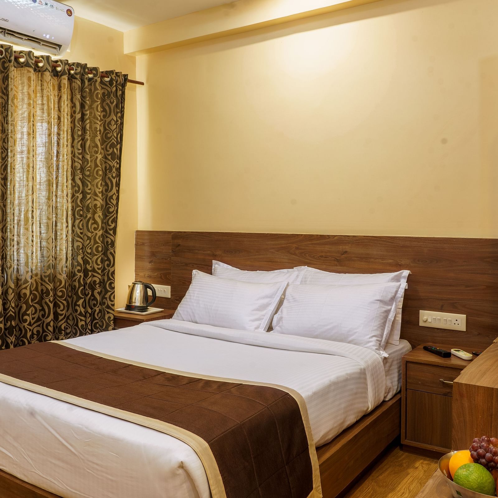 Standard room with bed and side table at Wyt Hotels, Rameswaram