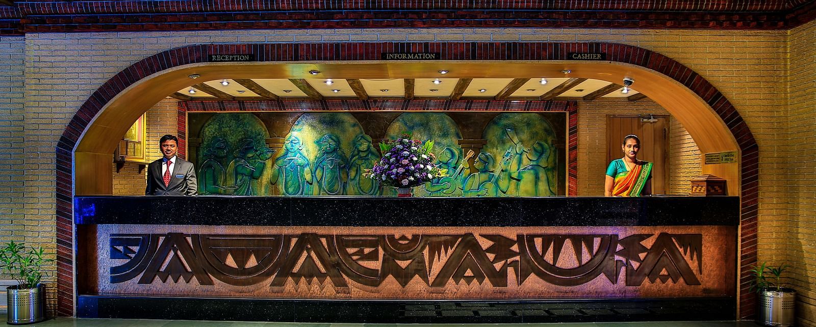 Reception of Tara, Comfort Hotel in Hyderabad - Ramoji Film City with two receptionists standing at either corners of the table