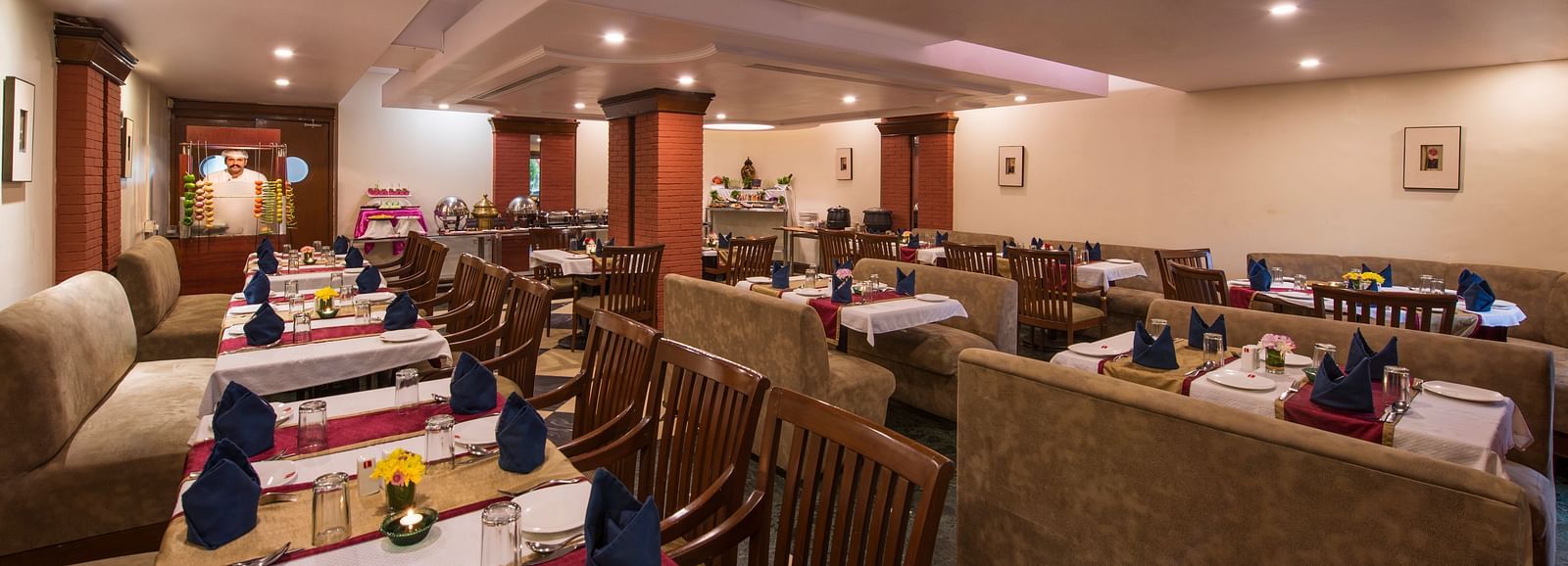 A warmly lit restaurant featuring multiple dining tables at Lords Inn Vadodara 