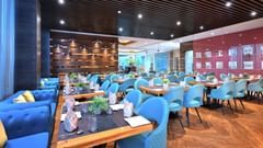 An image of Sumac Restaurant with cosy corner seats and warm lighting - Golden Tulip, Agra