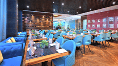 An image of Sumac Restaurant with cosy corner seats and warm lighting - Golden Tulip, Agra