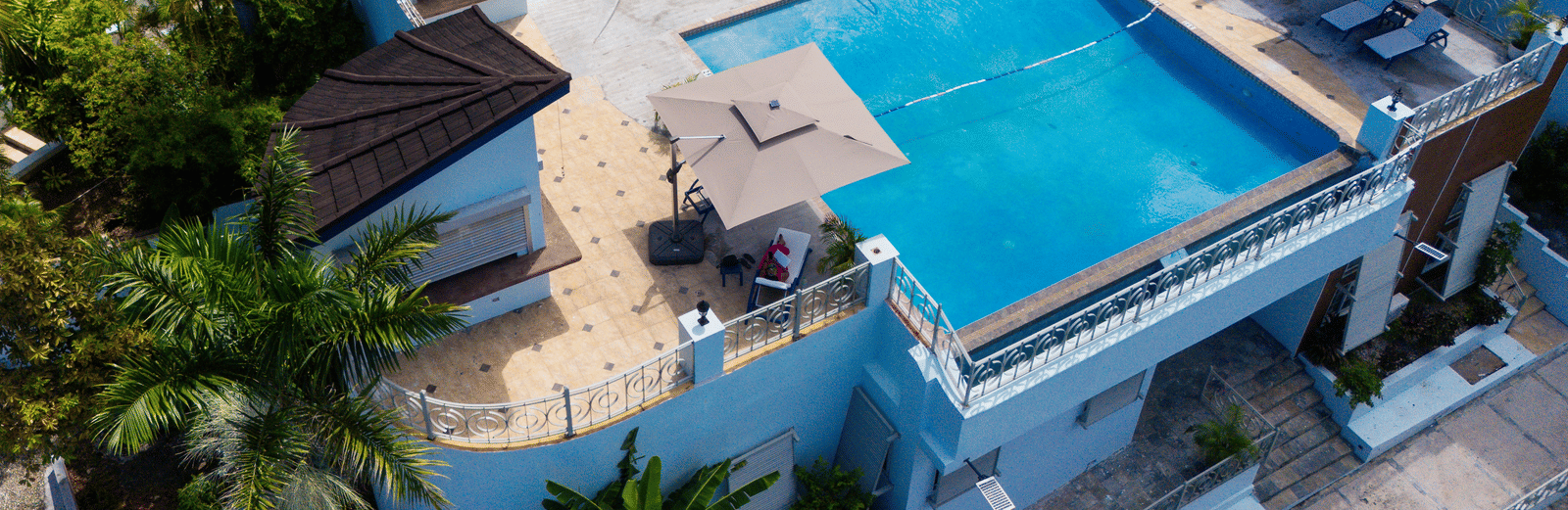 An aerial view of a rooftop pool surrounded by greenery on all sides of the Jamaica Hotel, Hotel 39 (Montego Bay) - Closest Jamaican Restaurant