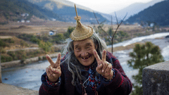 an old person showing the victory sign