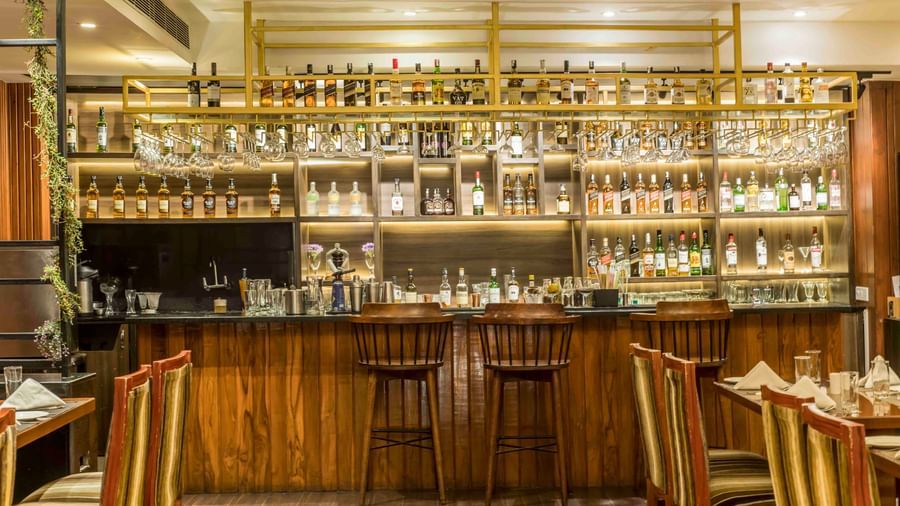 Well-lit hotel bar with a wide selection of bottles and several bar stools | The Citi Residenci Hotel Durgapur