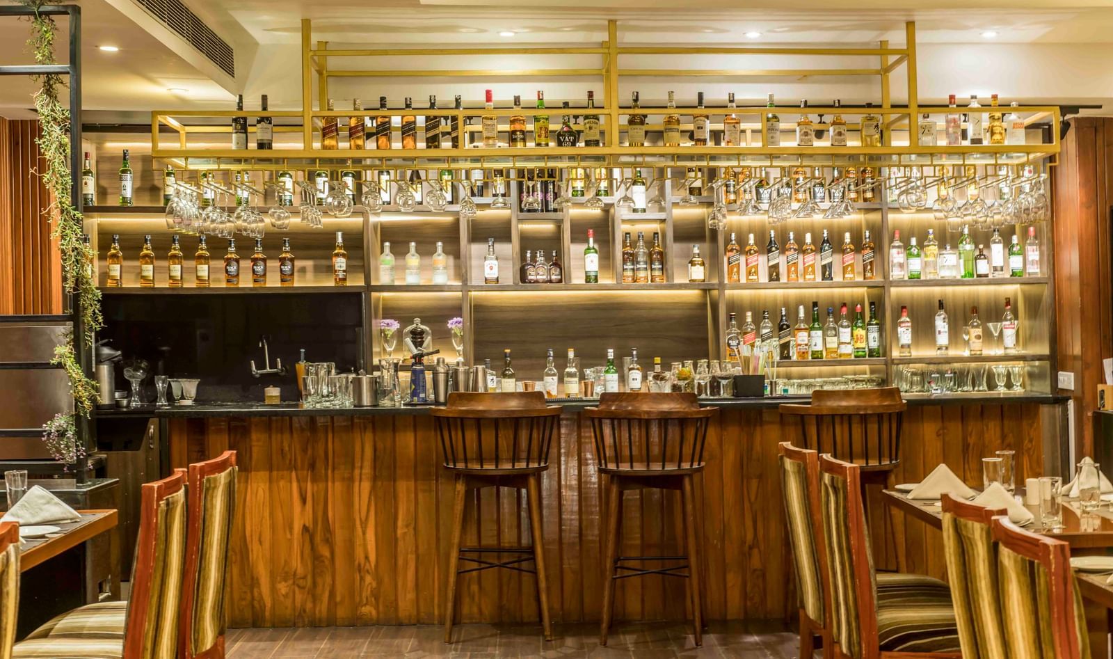 Well-lit hotel bar with a wide selection of bottles and several bar stools | The Citi Residenci Hotel Durgapur