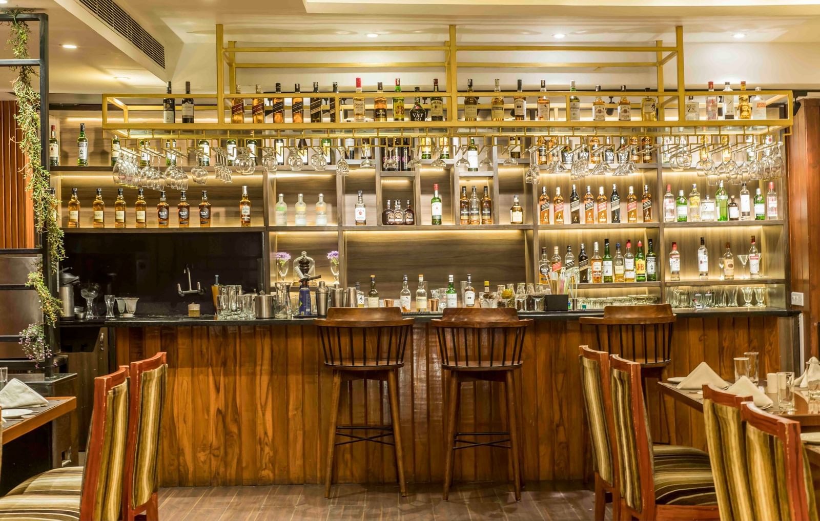 Well-lit hotel bar with a wide selection of bottles and several bar stools | The Citi Residenci Hotel Durgapur