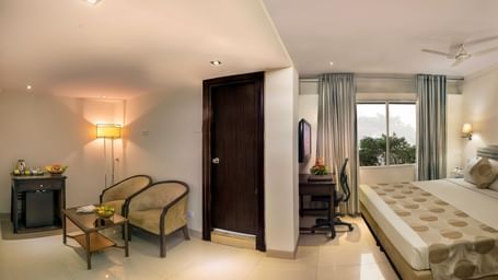 Elegant guest room at Lords Eco Inn Dahej with warm lighting, seating area, and comfortable bedding.