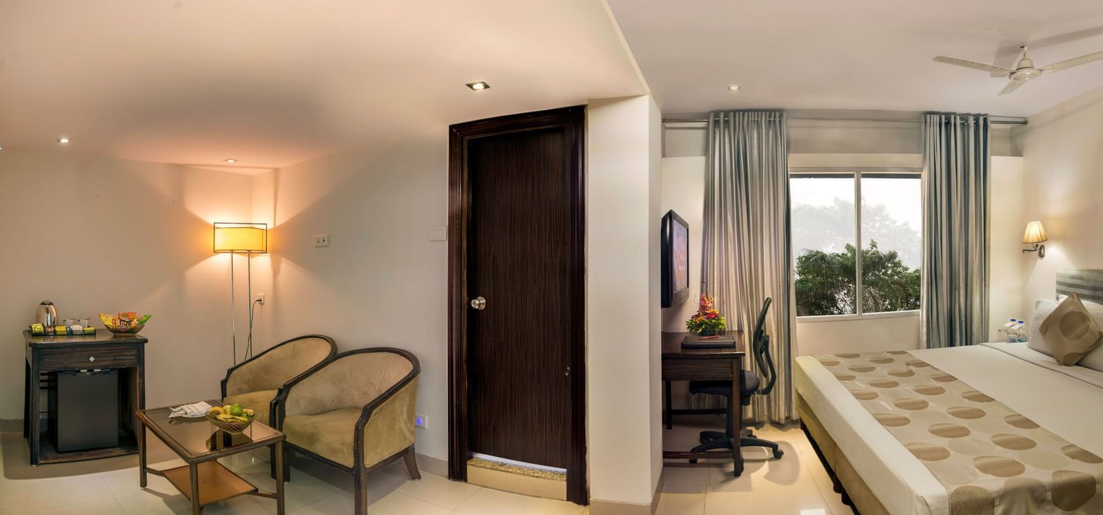 Elegant guest room at Lords Eco Inn Dahej with warm lighting, seating area, and comfortable bedding.