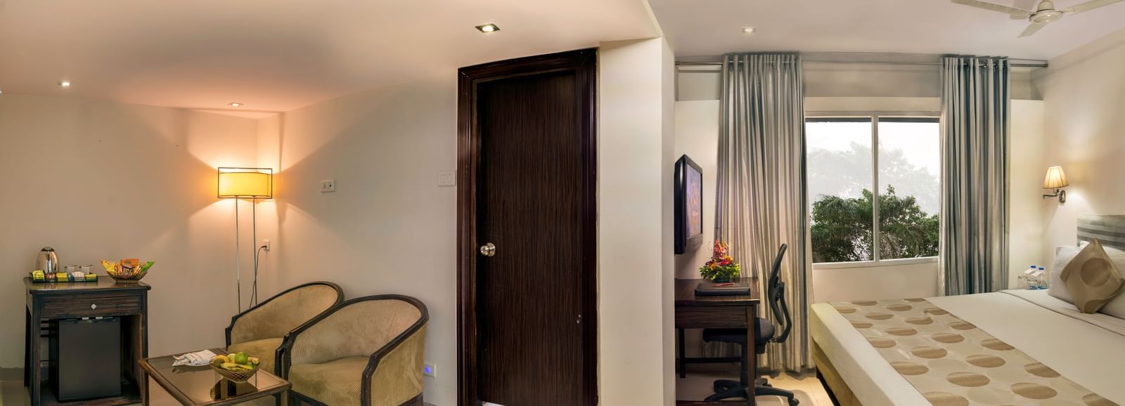 Elegant guest room at Lords Eco Inn Dahej with warm lighting, seating area, and comfortable bedding.