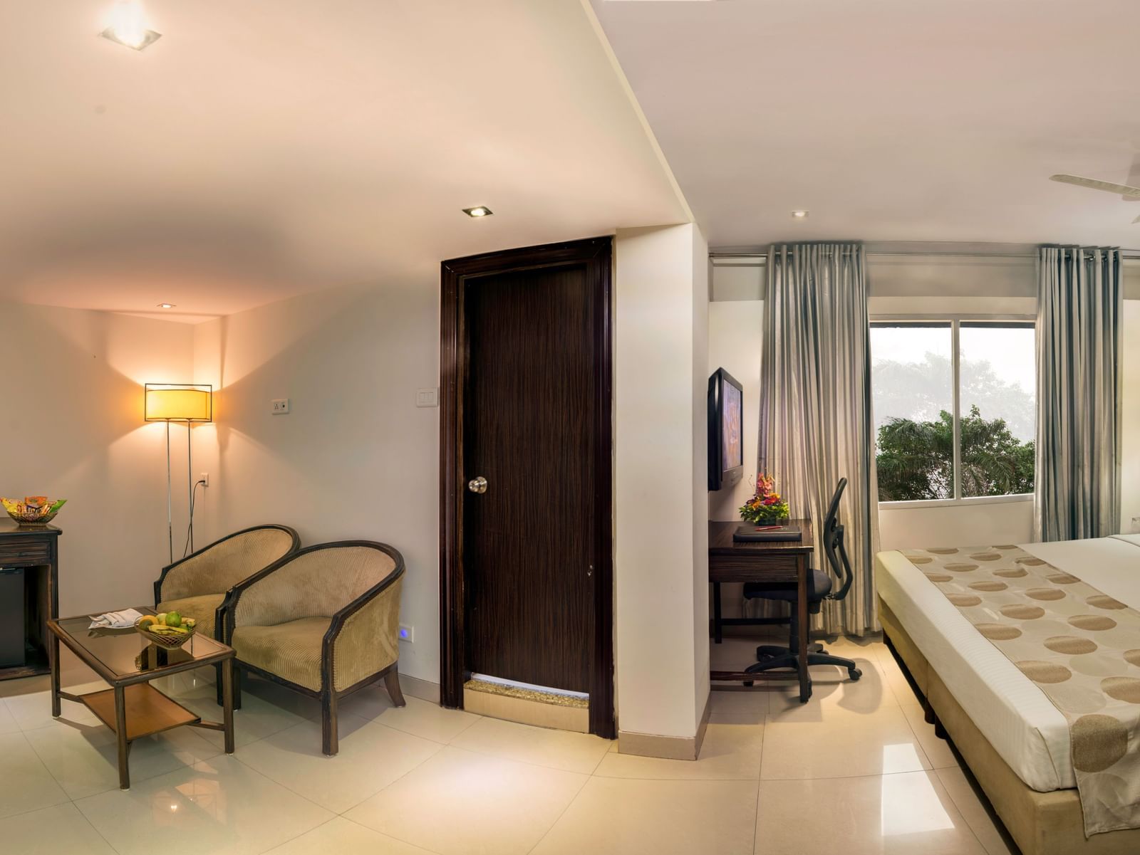 Elegant guest room at Lords Eco Inn Dahej with warm lighting, seating area, and comfortable bedding.