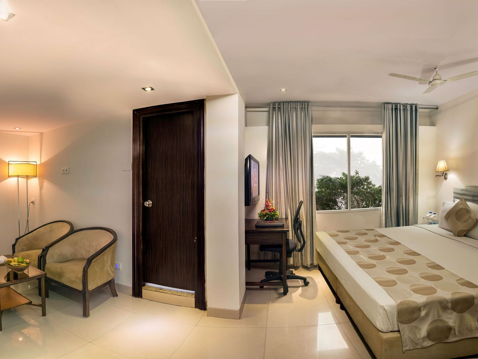 A hotel room with twin beds, armchairs, a desk, and soft lighting - Lords Eco Inn Dahej