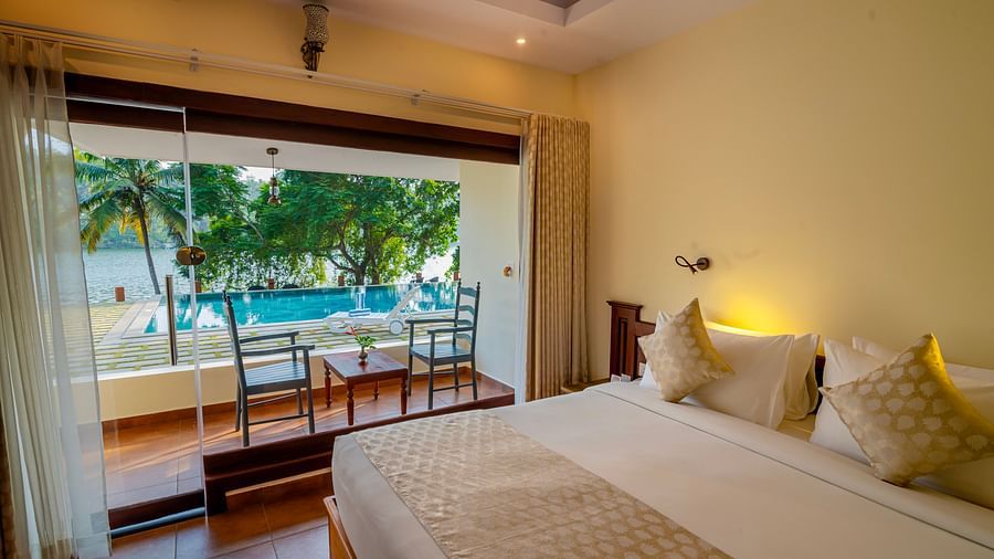 Spacious bedroom with a comfortable bed and a view of the pool and greenery.
