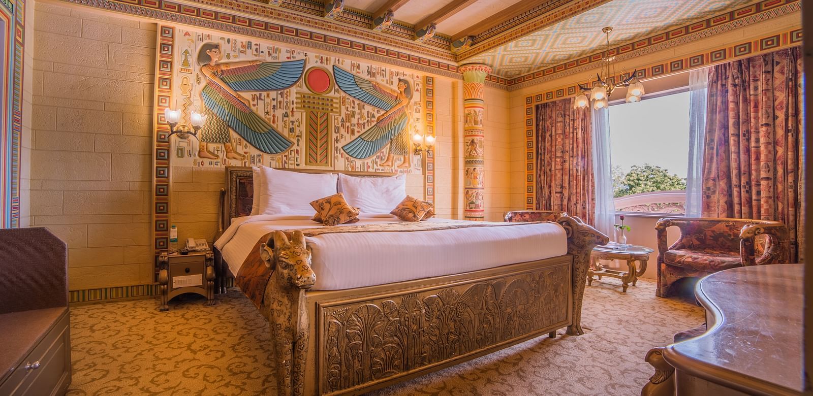 A lavish hotel room with golden decor and detailed wall designs, creating a royal ambiance at  Sitara Luxury Hotel in Hyderabad near Ramoji Film City.
