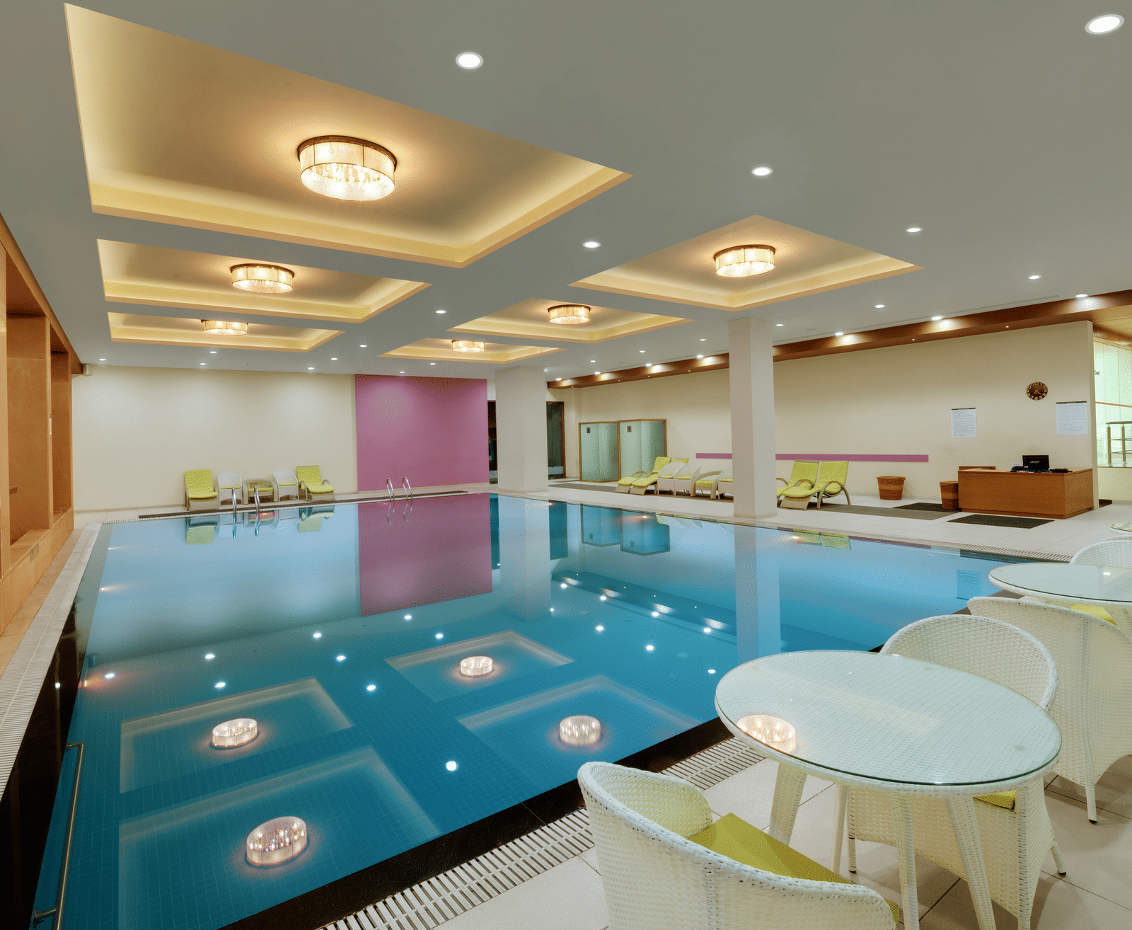 Indoor swimming pool with lounge chairs at Narayani Heights Hotel & Resorts, Ahmedabad.