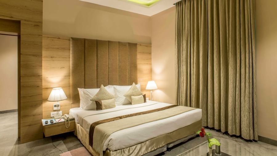 A comfortable and inviting hotel bedroom at Citi Residenci  features a king size bed and warm lighting | The Citi Residenci Hotel Durgapur