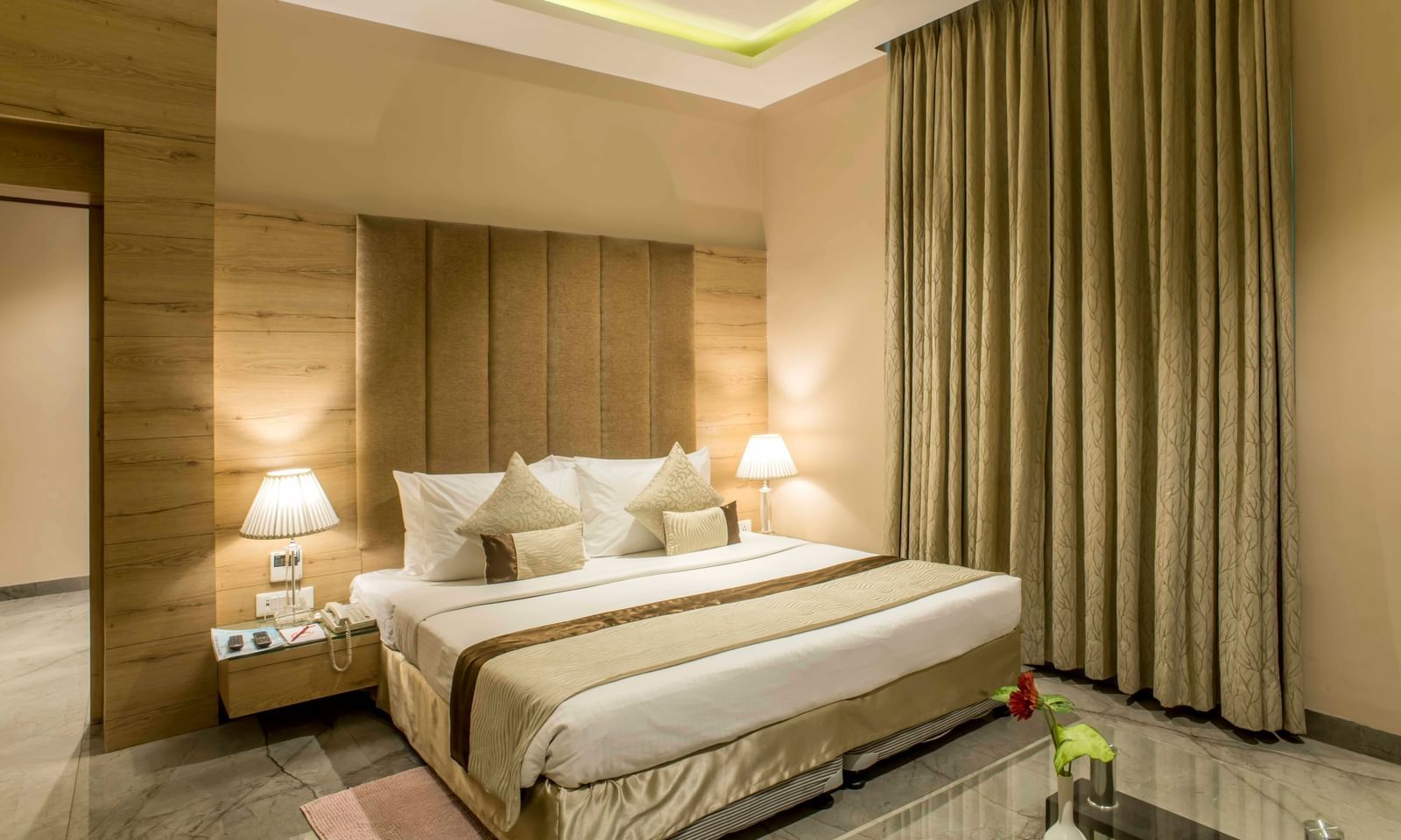 A comfortable and inviting hotel bedroom at Citi Residenci  features a king size bed and warm lighting | The Citi Residenci Hotel Durgapur