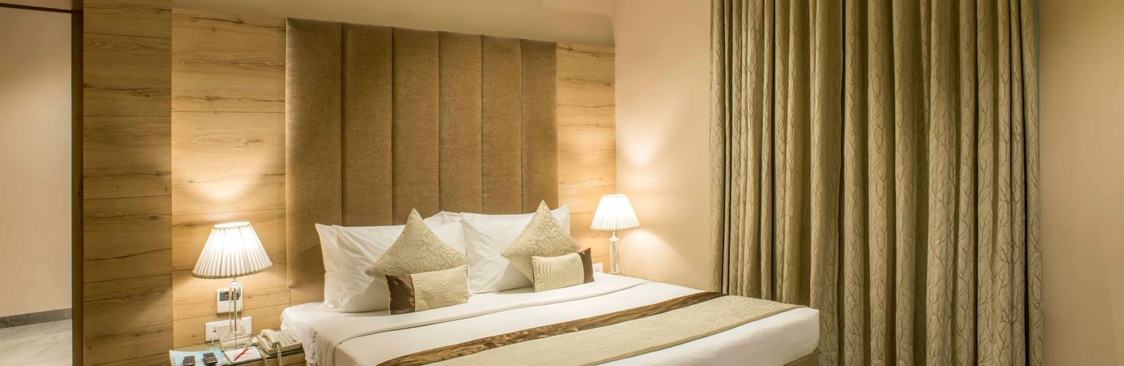 A comfortable and inviting hotel bedroom at Citi Residenci  features a king size bed and warm lighting | The Citi Residenci Hotel Durgapur