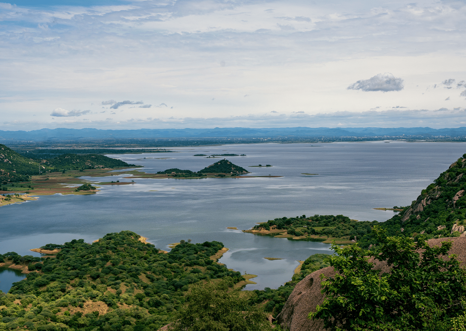 Panoramic landscape showing Badi Lake stretching out amidst green hills.