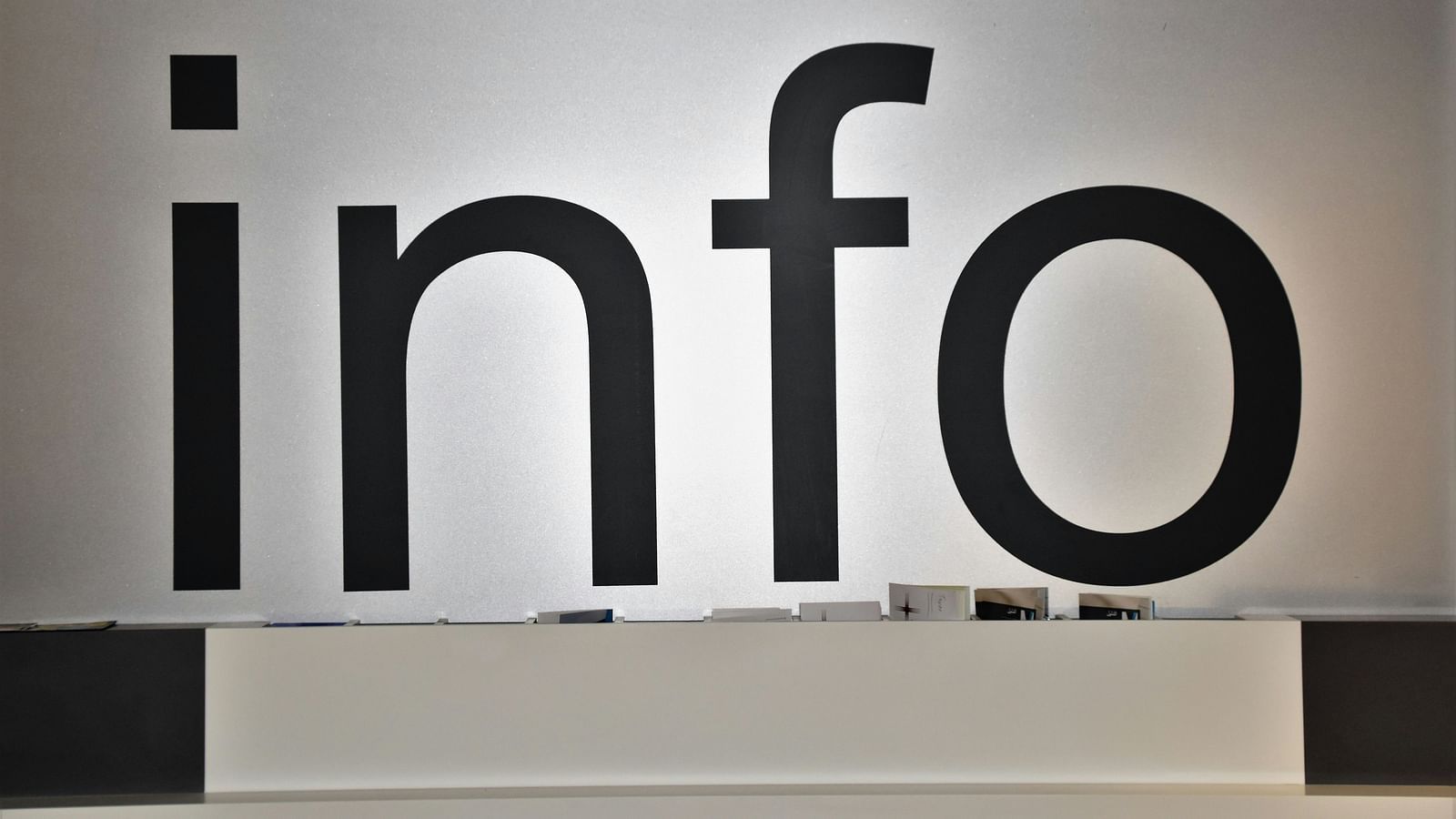 a close up shot of Info written on a wall with a table in the foreground