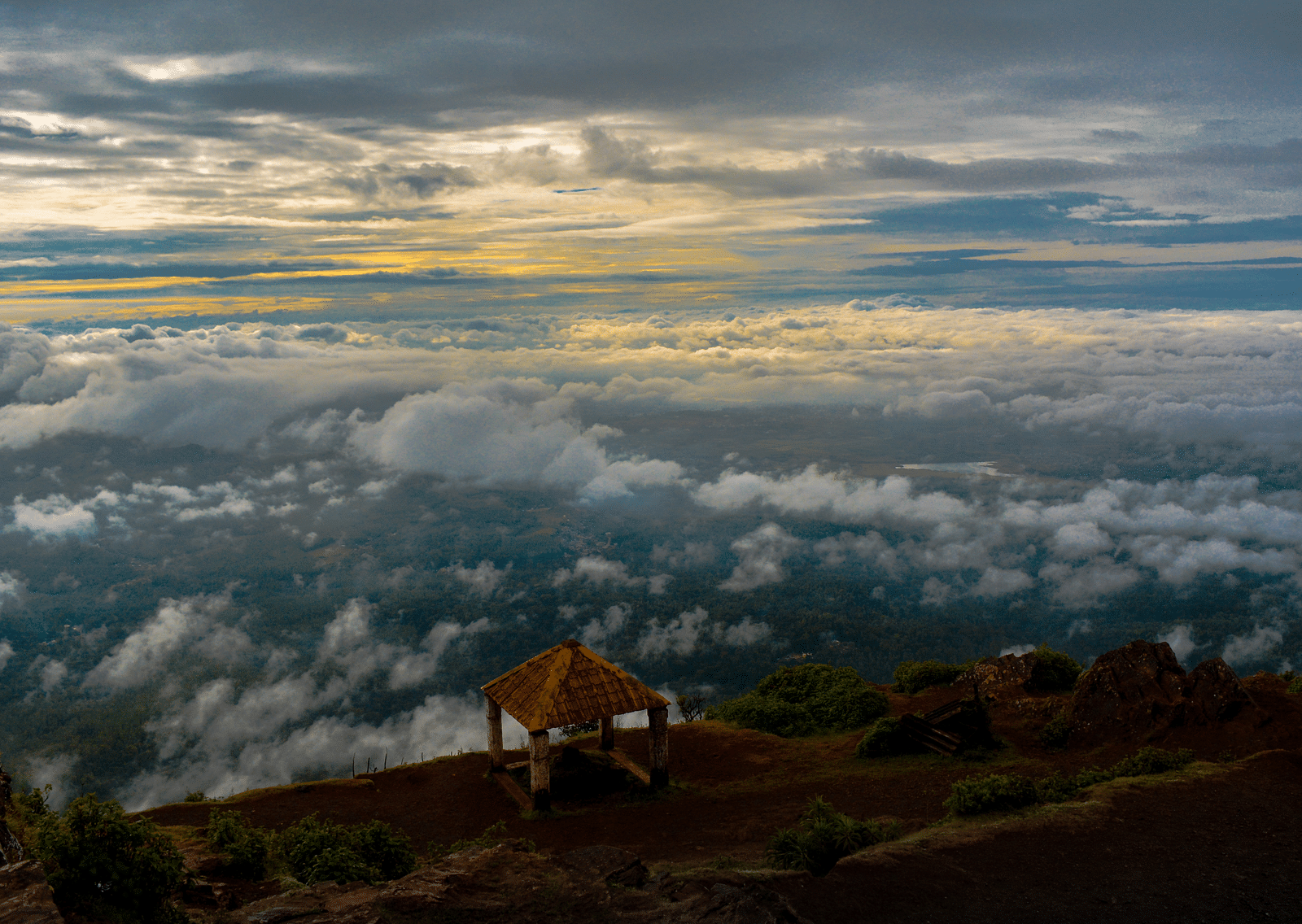 An overview of the western ghats with clouds floating above the valley. 