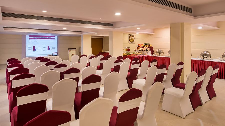 Another conference room shows rows of empty chairs facing a screen, ready for a presentation - Lords Inn Vadodara