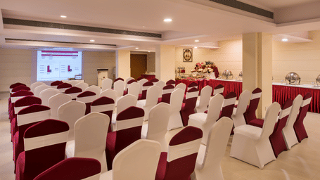 Conference room at Lords Inn Vadodara, featuring rows of empty chairs facing the screen, ideal for business meetings in banquet halls in Vadodara.